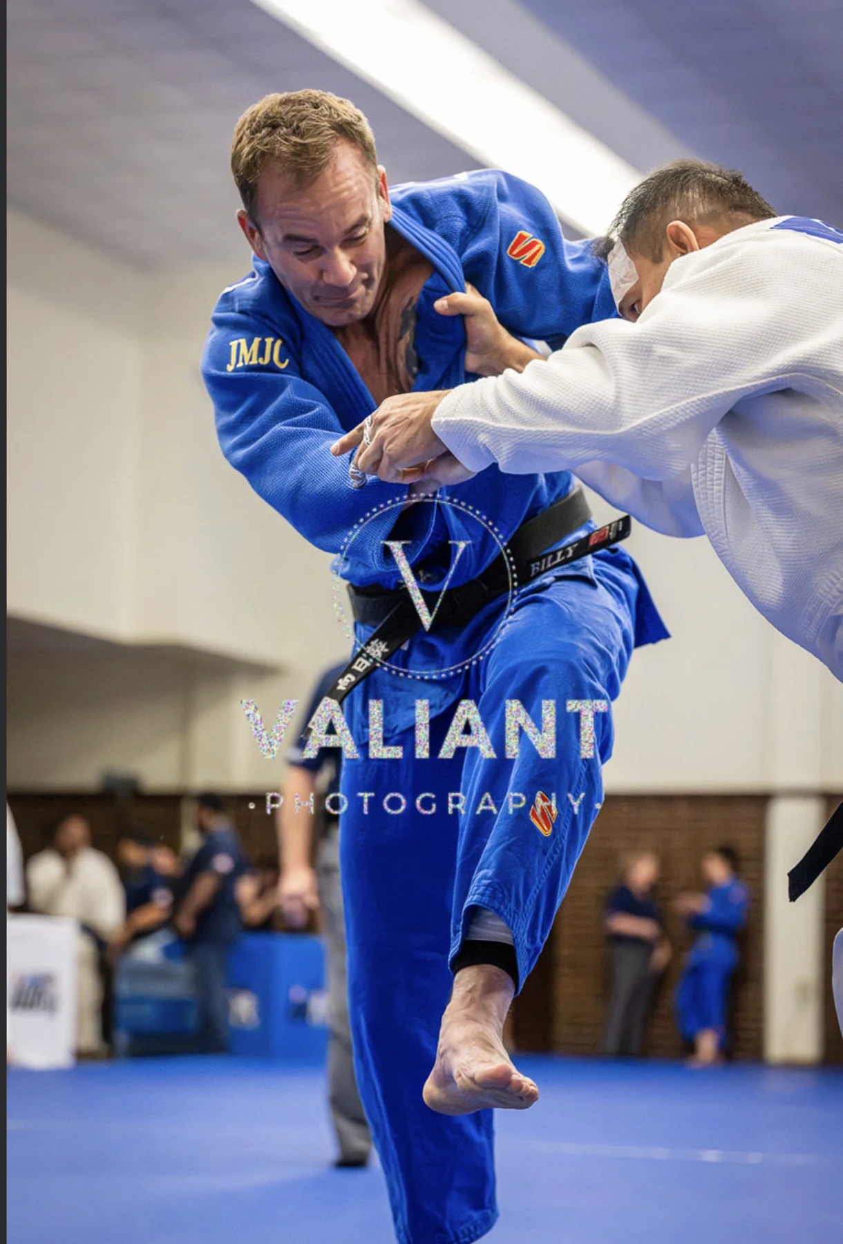 Billy Gavigan competing in blue, with Valiant Photography watermark retained